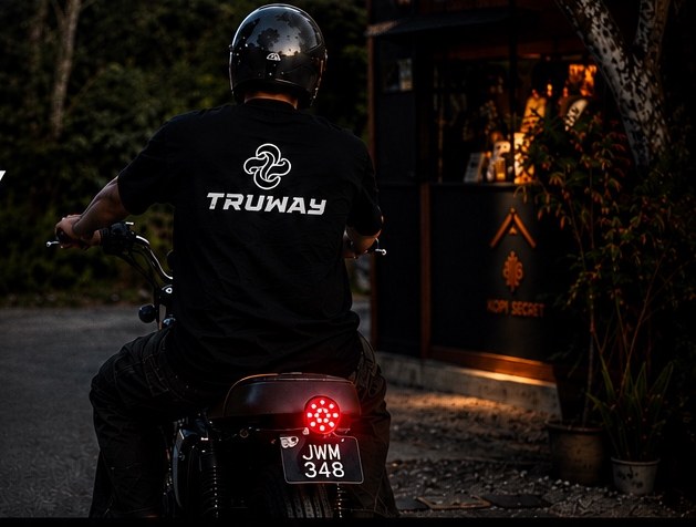 Rider in a TRUWAY tee outside Kopi Turu at dusk