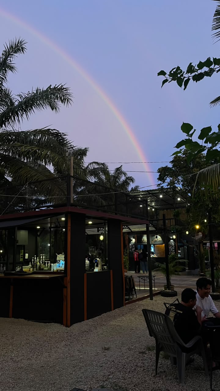 A rainbow over the Kopi Turu coffee bar at dusk